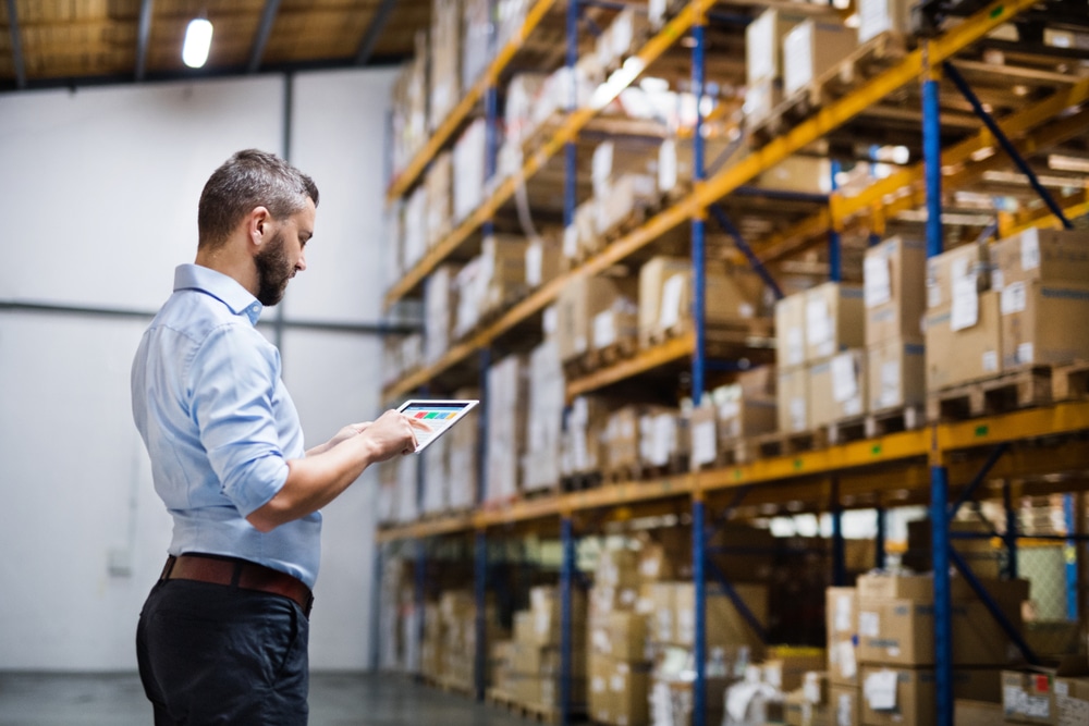 reviewing warehouse reporting by warehouse racks